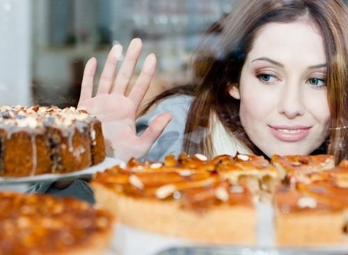 Femme souriante regardant l'affichage des desserts