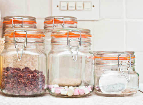 Bonbons et collations visibles dans des récipients en verre transparents sur la table de la cuisine