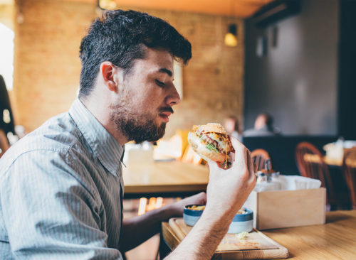 Guy mange au restaurant rapide