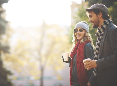 Femme et homme marchant et tenant des tasses à café