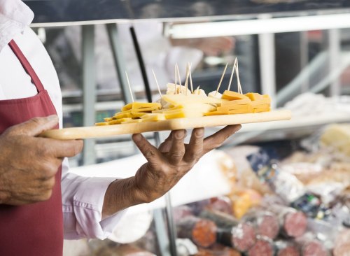 Homme tenant plateau de fromage par des échantillons gratuits en épicerie