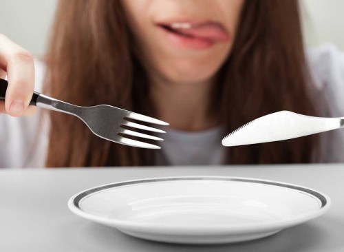 Assiette vide de couteau fourchette femme affamée