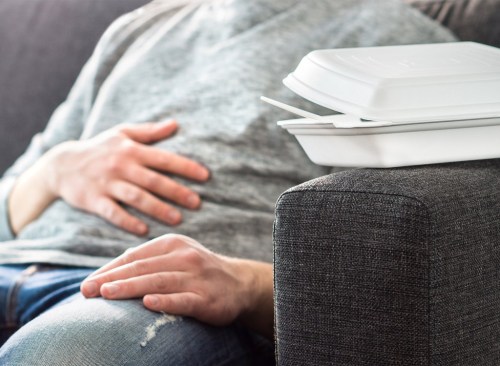 Homme souffrant d'indigestion après avoir trop mangé