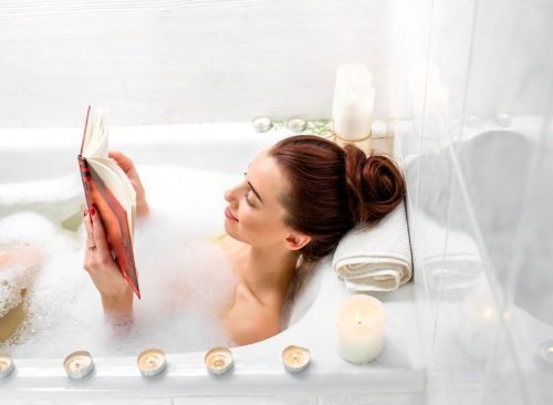 Femme lisant dans une salle de bain