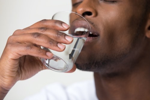 homme tient un verre d'eau potable