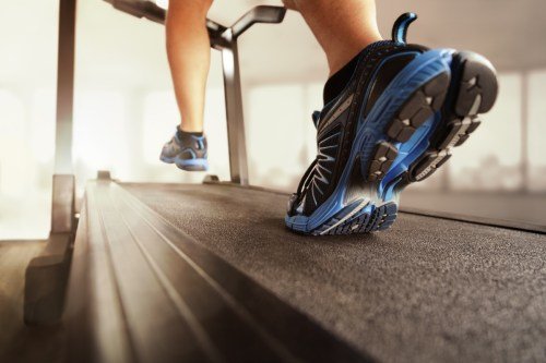 Homme qui court dans une salle de sport sur un concept de tapis roulant pour l'exercice, le fitness et un mode de vie sain