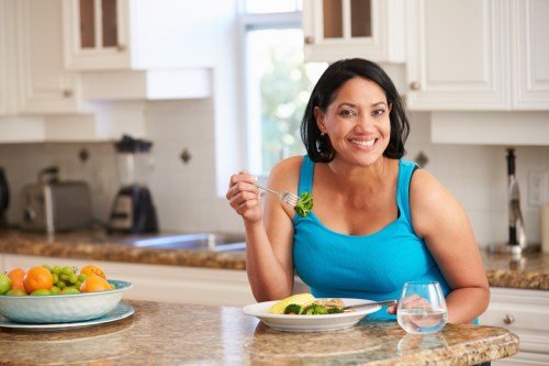 Femme mangeant des repas sains dans la cuisine