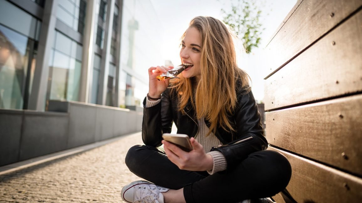 Femme mangeant une barre faible en glucides Atkins