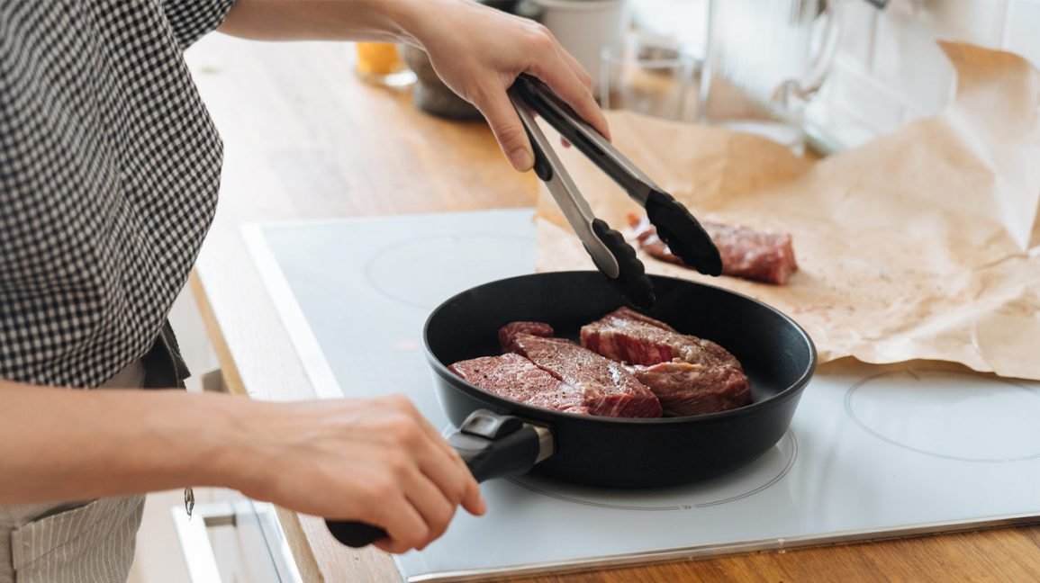 Personne qui prépare un steak riche en vitamine B12