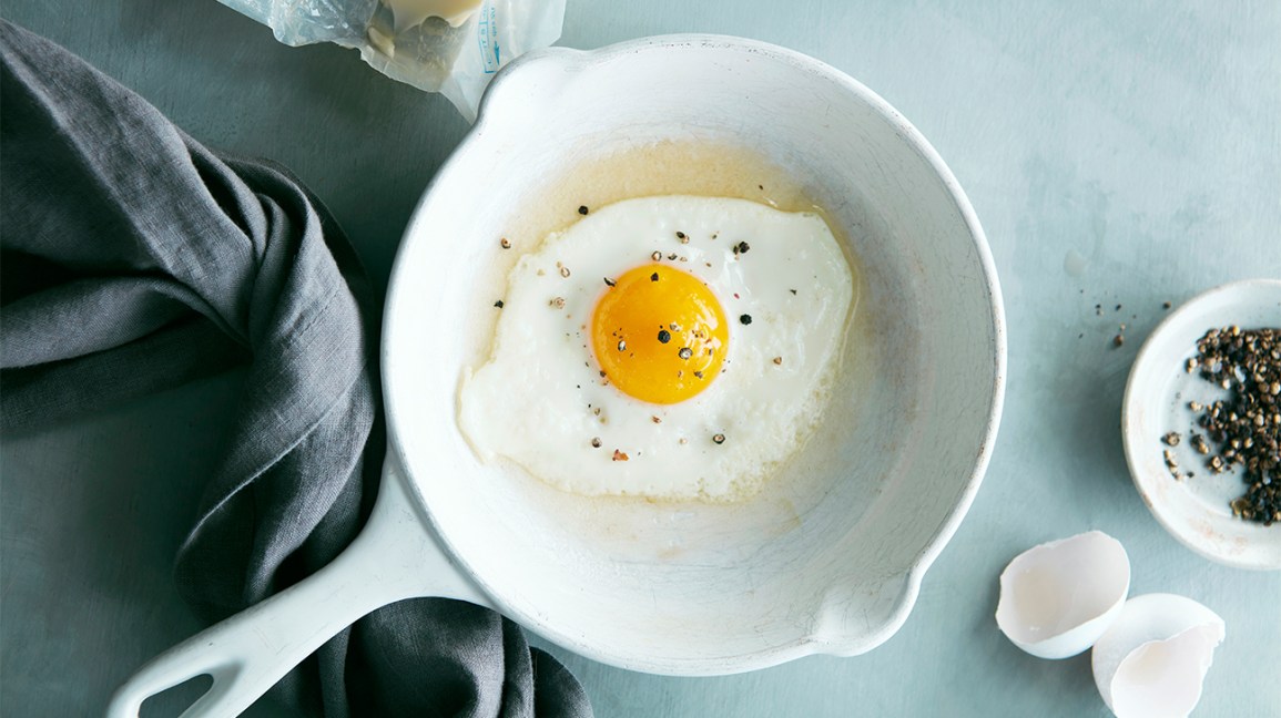 oeuf au plat avec du poivre concassé dans une poêle