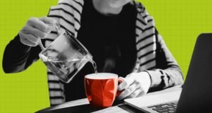 Image d'une personne versant de l'eau chaude dans une tasse alors qu'elle est assise devant un ordinateur portable