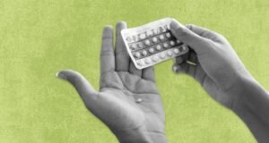 Une personne avec une boîte de contraceptifs en vente libre dans sa main.