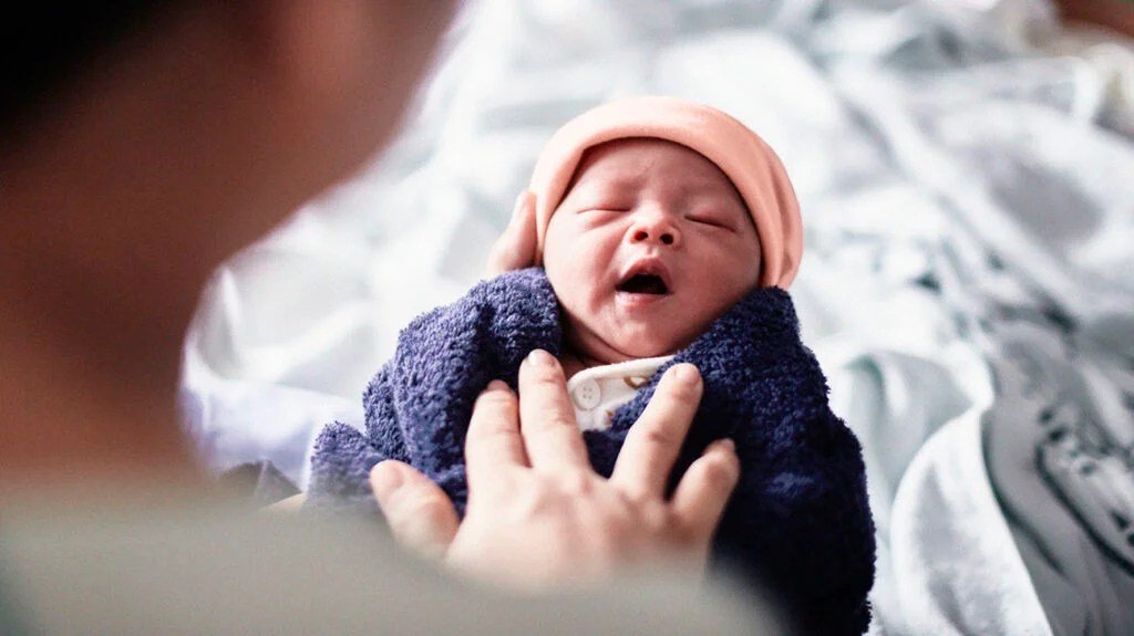 Bambina carina con gli occhi chiusi con la madre sul letto